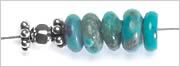sterling silver faceted rondelles, magnesite rondelles and one sterling silver faceted round bead, strung onto beading wire.